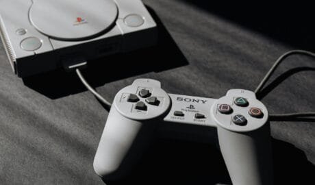 photo of play station game console and remote controller